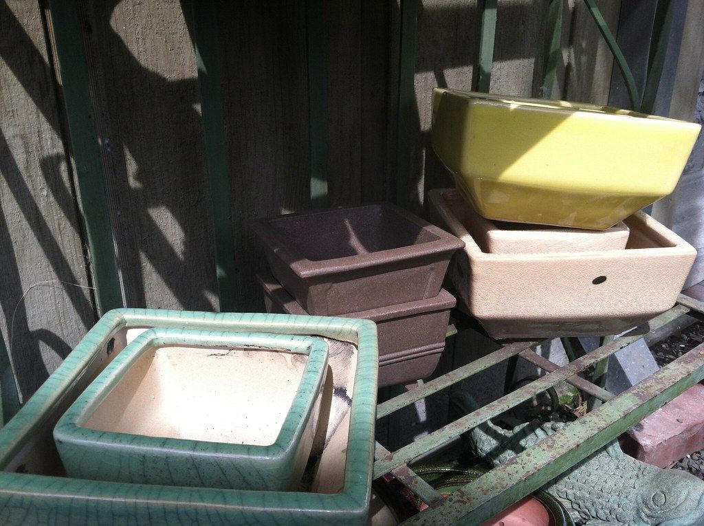 棚に積み重ねられた色や形の違う盆栽鉢